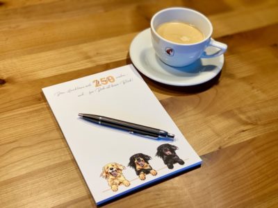 Block mit Hovawart und einer Tasse Kaffee